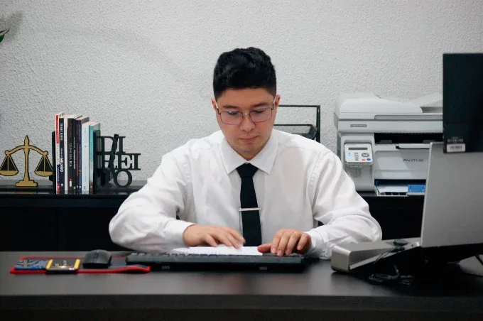 Lucas Souza trabalhando em sua mesa no escritório